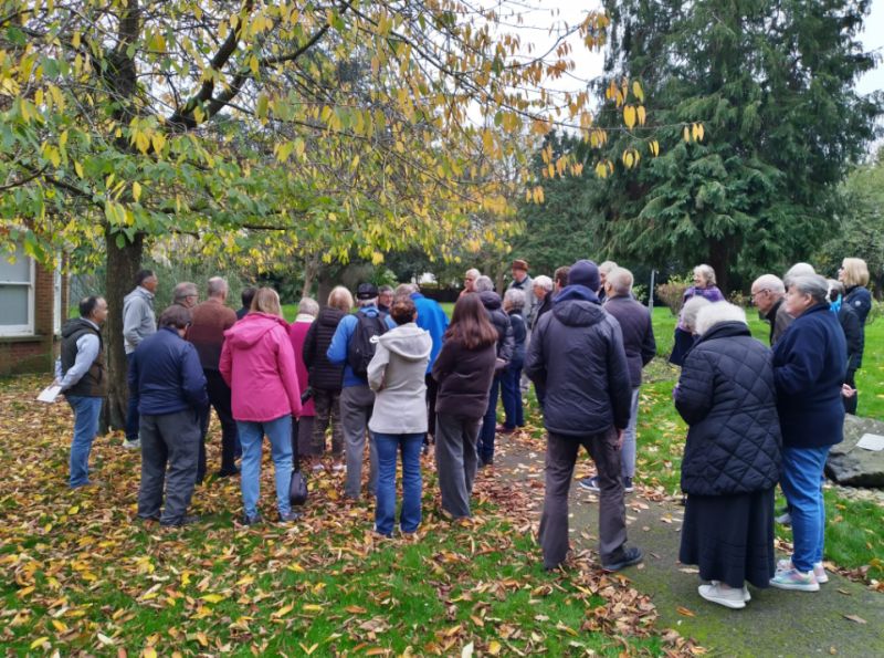 Mystery London Astronomy Tour (Hayes) Group
The whole group (including guests from flamsteed AS) listening to Greg talk about John Hussey who used to live at what is now the Library and who had a large observatory in the garden.
Hussey was an amateur astronomer and established
a signifcant, personal observatory at Hayes, with a
6.5-inch-diameter (170 mm) refracting telescope by
Joseph von Fraunhofer, a Newtonian telescope of 7
ft focal length by William Herschel, and a 9.3-inch
Gregorian-Newtonian.
His observations On Venus rotation and Sunspots presented to the Royal Astronomical Society
in 1847. Hussey also compiled star maps, one of which earned him a prize from the Berlin Academy in 1831

Photo by Jim Worthington
Link-words: London MLAT2024